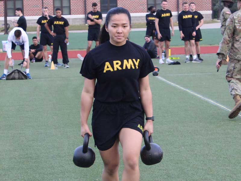 a student cadet carrying kettleballs during an exercise drill